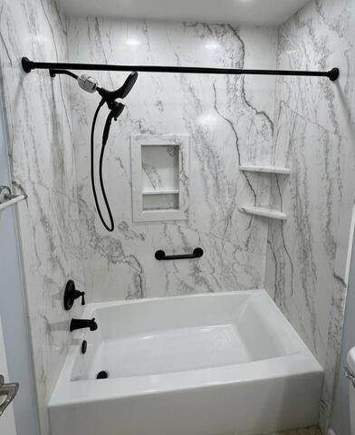 Bathroom remodel showing tub and shower with white-gray marble-look surround
