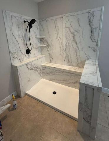 Bathroom remodel featuring a walk-in shower with white and gray marble-look walls