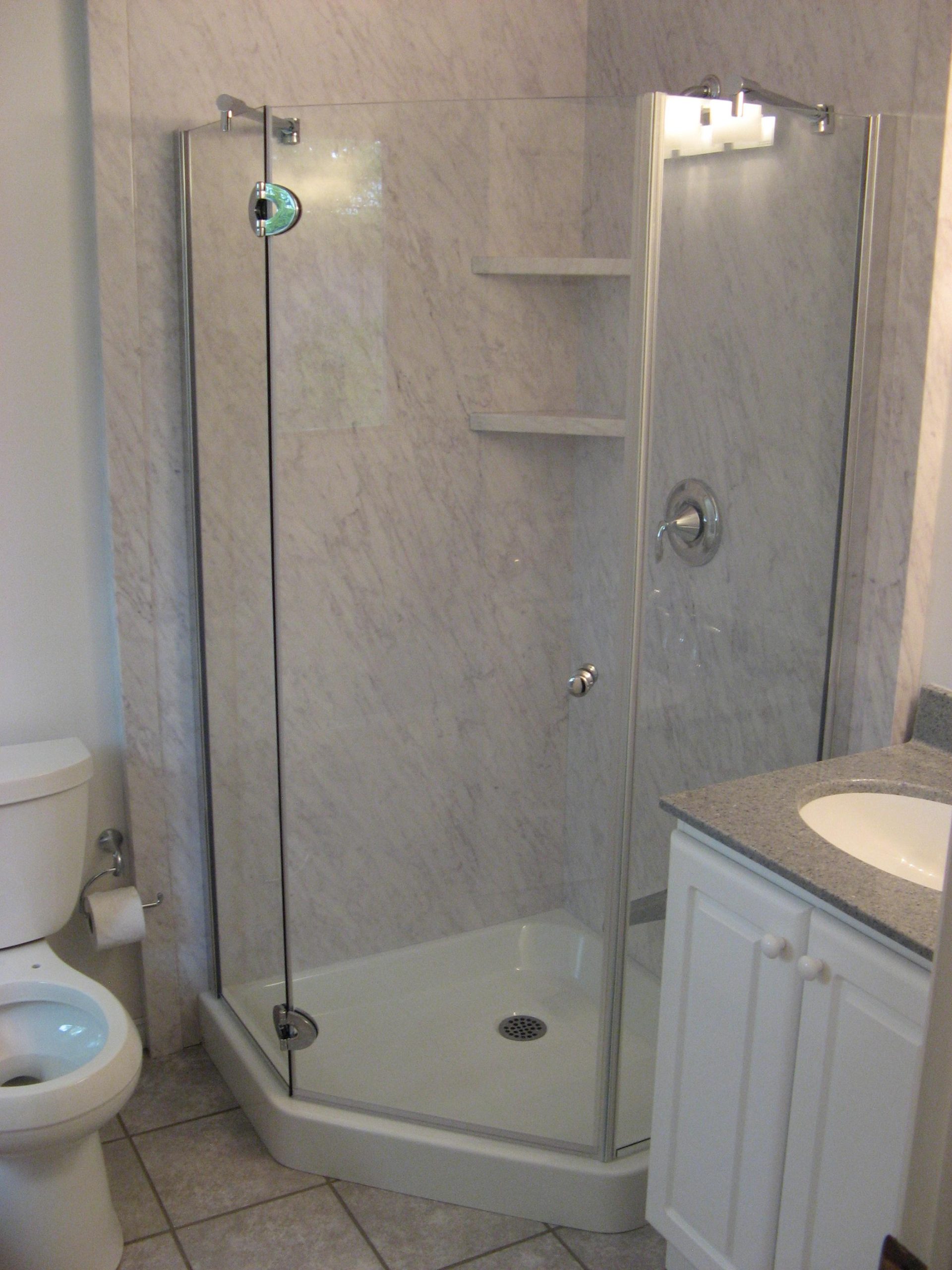 Renovated corner walk-in shower with updated walls and fixtures